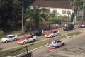 L’un des voleurs (en blanc sur la chaussée) arrache un sac à travers la portière d’une voiture coincée dans l’embouteillage. © Capture d’écran d’une vidéo amateur/Gabonreview