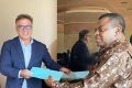 Echange symbolique de documents entre Sébastien Bottari et Mathieu Taty, le 23 août 2022 à Libreville. © 7joursinfo.com