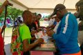 Des jeunes sacrifiant au rituel d’inscription au 10km de Pog devant le Comité d’organisation. © GabonReview