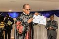 Le chancelier Afrique de la Harvest Christian University Kamdem Nounga brandissant l'attestation de réussite des méritants. © D.R.