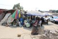 Quelques déguerpis assis devant leurs abris précaires et dégradés, construits à la hâte et avec des matériaux de récupération. © GabonReview
