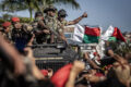 Des membres de l'unité CAPSAT de l'armée malgache réagissent à leur accueil enthousiaste lors d'un rassemblement de la société civile réclamant la démission du président Andry Rajoelina, avant de se rendre au palais présidentiel d'Antananarivo, le 14 octobre 2025. © LUIS TATO / AFP