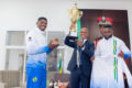 Le capitaine Wora Mamadou présentant le trophée au ministre Paul Ulrich Kessany ce mercredi à Libreville. © D.R