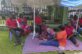 Les agents de la CNNII assis au pied de l’immeuble Arambo, le 20 mai 2026 à Libreville. © GabonReview