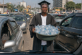 La toge et la bassine : l'image résume le sort de milliers de jeunes diplômés gabonais contraints de survivre par les petits métiers, comme le révèle le RNDH 2026. © Illustration générée par IA / GabonReview