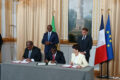 À la table de signature, Léod-Paul Batolo (Comilog), Sosthène Nguema Nguema (ministre des Mines et des Ressources géologiques) et Christel Bories (Eramet), avec en arrière-plan les présidents Brice Clotaire Oligui Nguema et Emmanuel Macron, le 20 juillet 2026 à l'Élysée. © D.R.